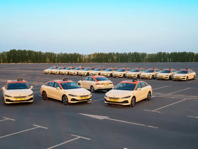 Fleet of MG8 PHEV plug-in hybrid taxis lined up in a large parking lot