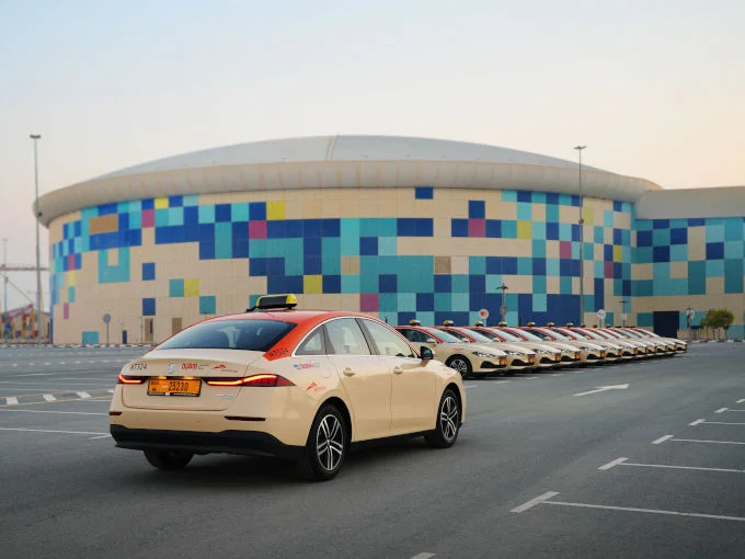 Rear view of an MG8 PHEV taxi with a row of MG8 PHEV taxis parked behind it in the UAE