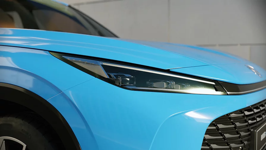 Close-up of the LED headlight and front grille of a blue MG HS