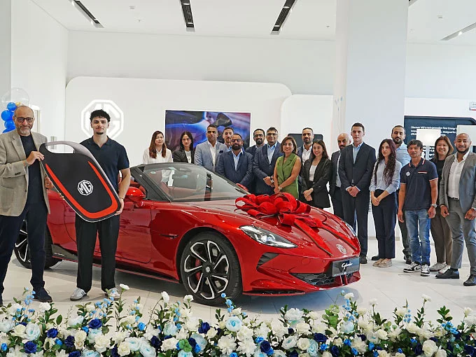 MG customer and team celebrating brand's global sales milestone