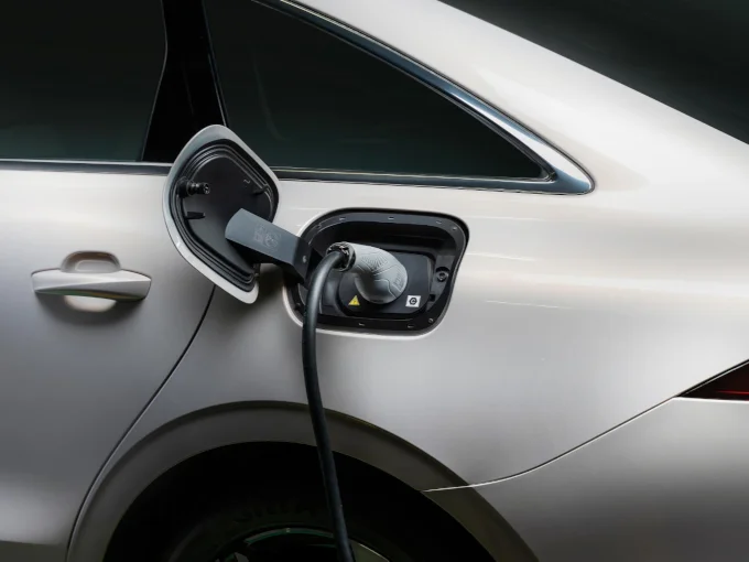 Charging cable plugged into the charging port of a white MG electric car